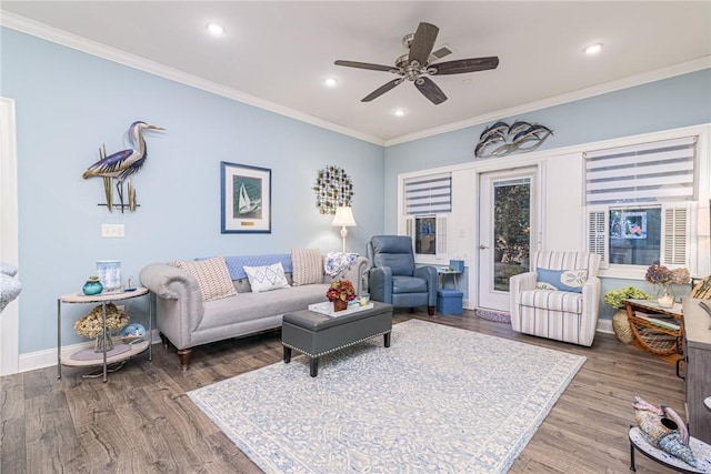 living room featuring hardwood / wood-style floors, ceiling fan, and crown molding