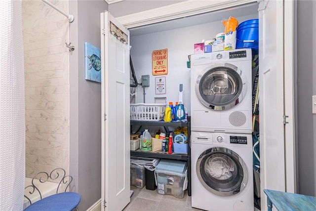 washroom featuring stacked washing maching and dryer and light tile patterned flooring