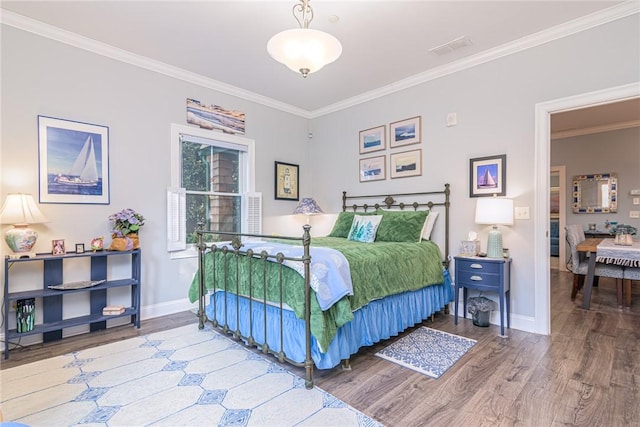 bedroom with ornamental molding and hardwood / wood-style flooring