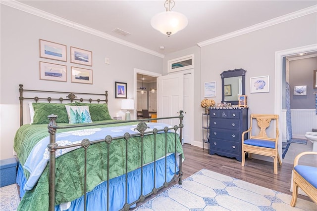 bedroom featuring ornamental molding, connected bathroom, and wood-type flooring