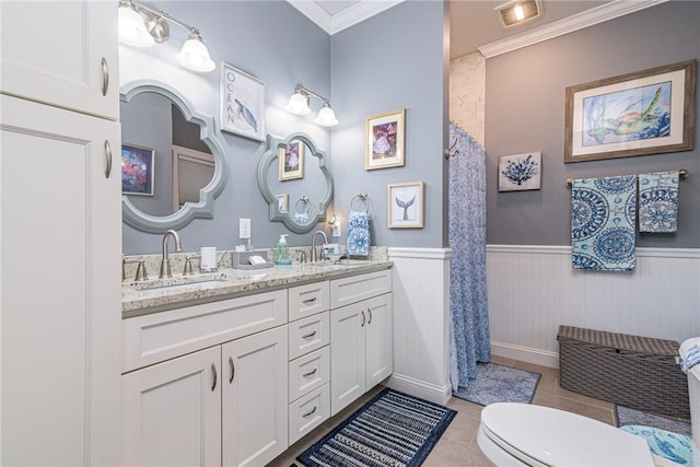 bathroom with toilet, tile patterned flooring, ornamental molding, and vanity