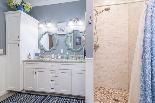 bathroom featuring a shower with shower curtain, vanity, and ornamental molding