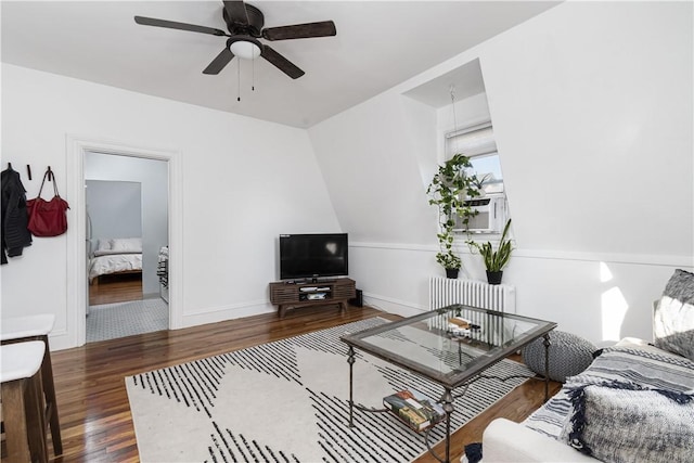 living room featuring hardwood / wood-style flooring, ceiling fan, cooling unit, and radiator