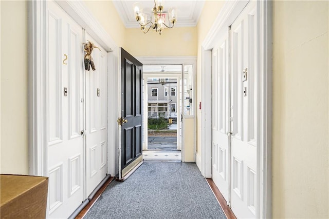 corridor featuring crown molding and an inviting chandelier