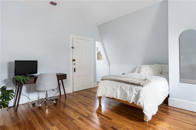 bedroom featuring hardwood / wood-style flooring and vaulted ceiling