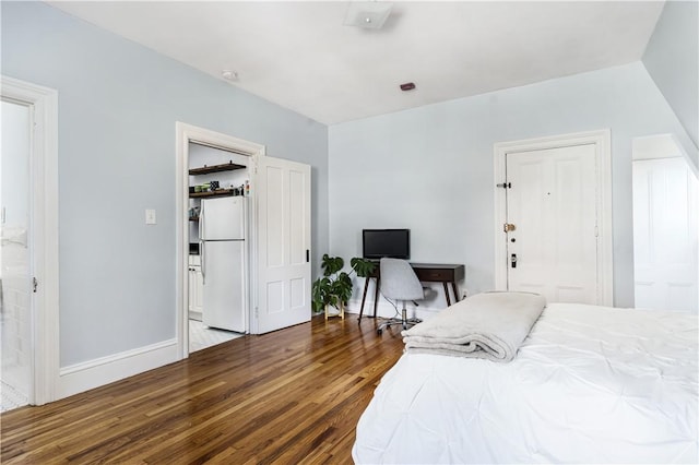 bedroom with hardwood / wood-style flooring and white fridge