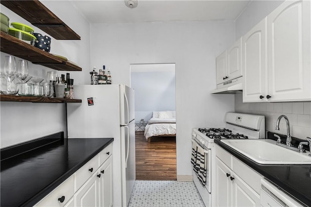 kitchen with white cabinets, backsplash, white appliances, and sink