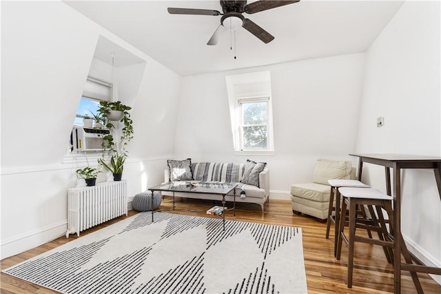 sitting room with wood-type flooring, radiator, cooling unit, and ceiling fan