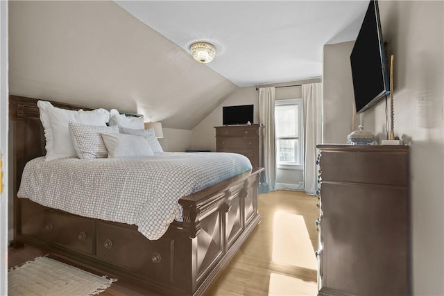 bedroom featuring lofted ceiling and light wood-type flooring