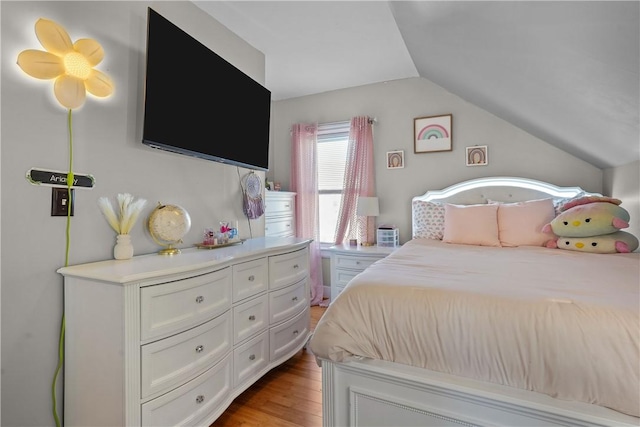 bedroom featuring lofted ceiling and light hardwood / wood-style flooring