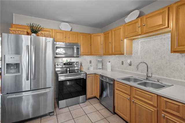 kitchen with light tile patterned flooring, decorative backsplash, stainless steel appliances, and sink