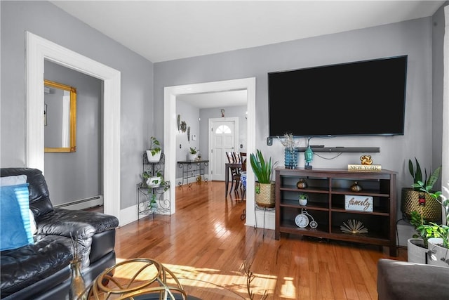 living room with hardwood / wood-style floors and a baseboard heating unit