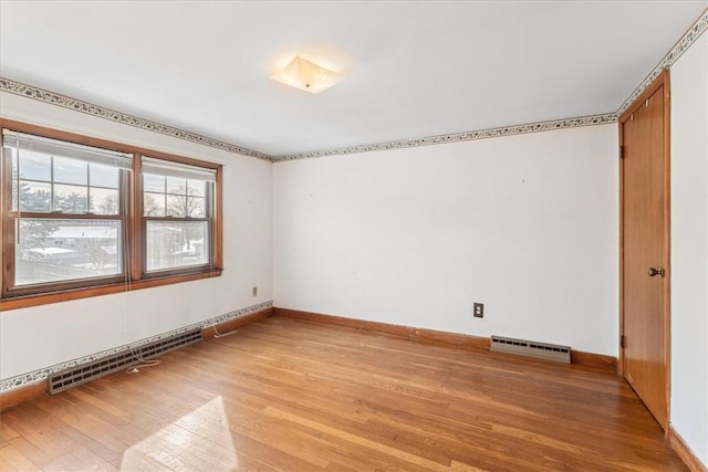 unfurnished room with light hardwood / wood-style floors and baseboard heating