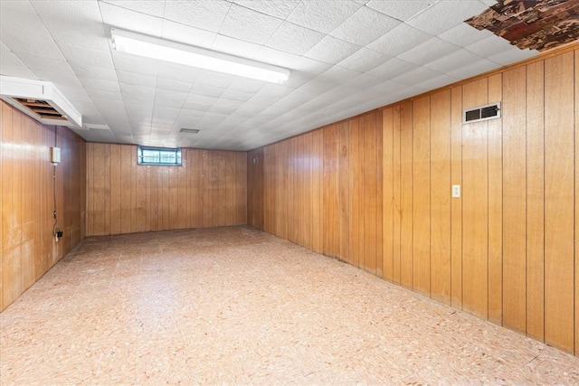 basement featuring wooden walls