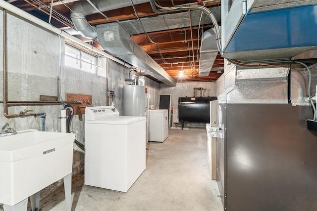 basement featuring water heater, washer / clothes dryer, and sink