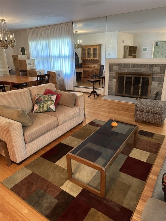 living room with a fireplace, a chandelier, and wood-type flooring