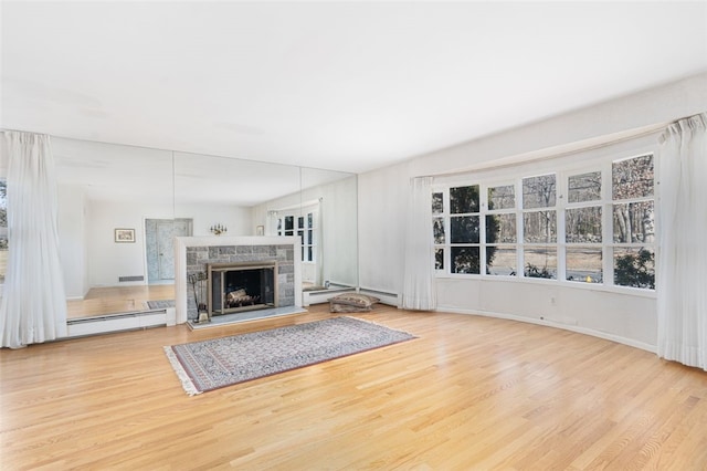 unfurnished living room featuring a fireplace and light hardwood / wood-style flooring