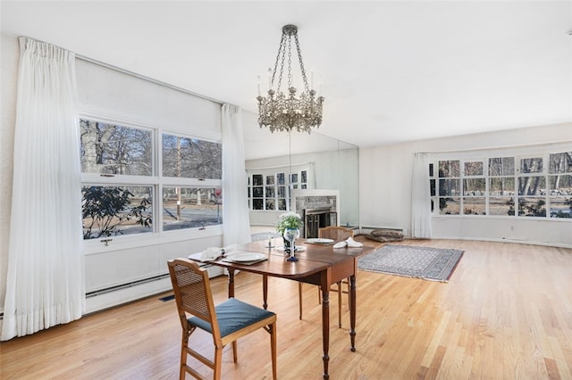 dining room with light wood-type flooring and a notable chandelier