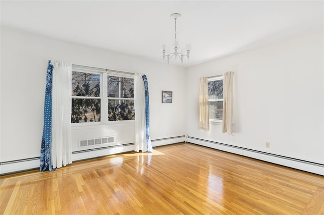 unfurnished room with an inviting chandelier, a baseboard radiator, and hardwood / wood-style floors