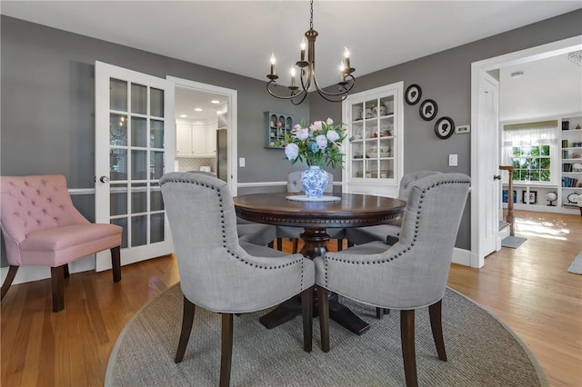 dining space with wood-type flooring and a chandelier