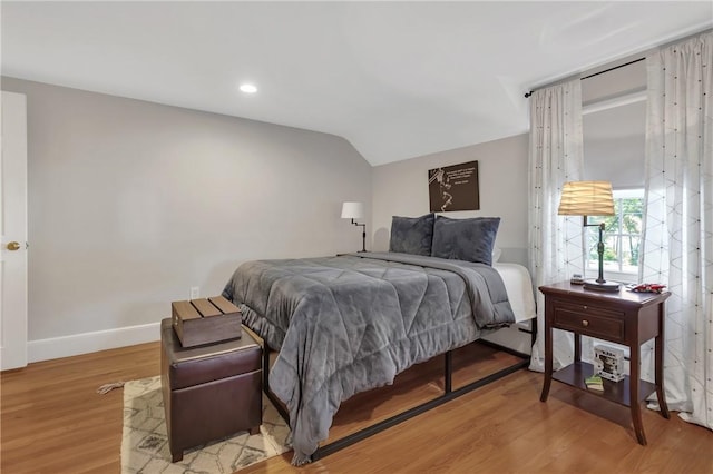 bedroom with lofted ceiling and wood-type flooring