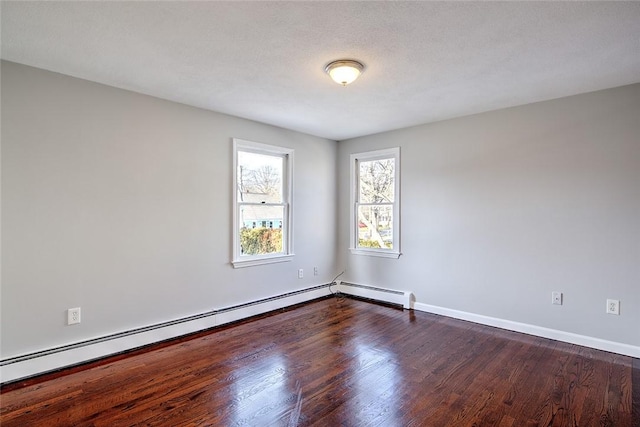 unfurnished room featuring a baseboard heating unit, a textured ceiling, and dark hardwood / wood-style flooring