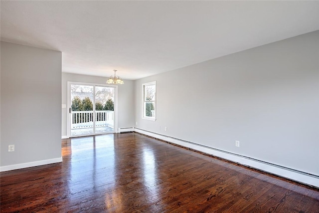 empty room featuring dark hardwood / wood-style flooring, a baseboard radiator, and a chandelier