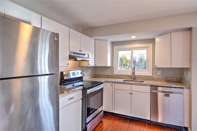 kitchen featuring stainless steel appliances, light stone countertops, white cabinetry, and sink