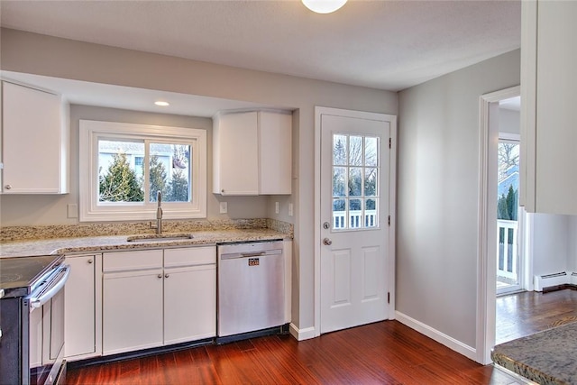 kitchen with dark wood-type flooring, stainless steel appliances, a baseboard heating unit, white cabinetry, and sink