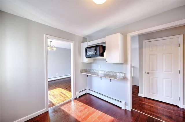 kitchen featuring dark hardwood / wood-style flooring, white cabinets, a baseboard heating unit, and light stone countertops