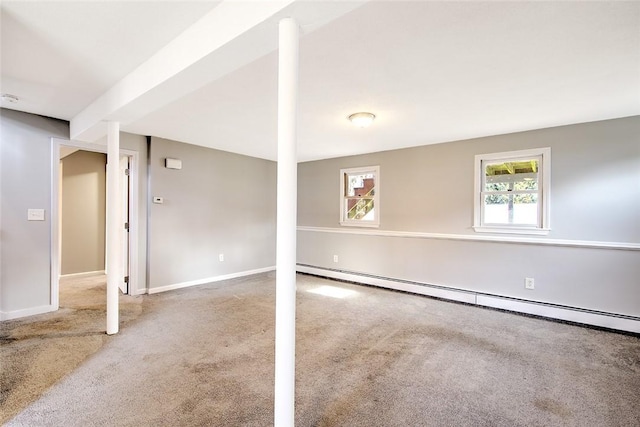 basement featuring a baseboard heating unit and carpet