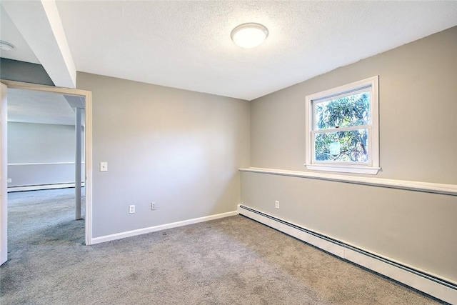 spare room featuring a baseboard radiator, a textured ceiling, and light carpet