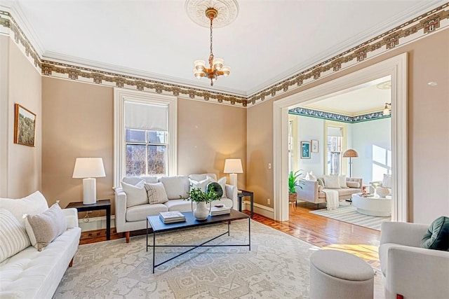 living room featuring an inviting chandelier, crown molding, and wood-type flooring