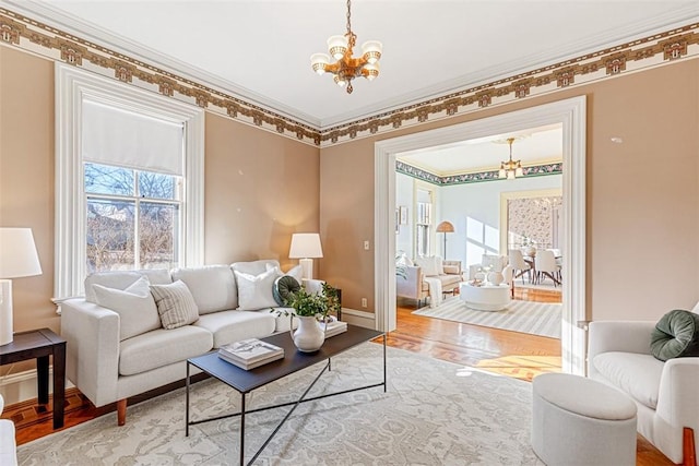 living room featuring ornamental molding, a chandelier, and wood-type flooring