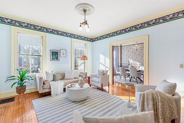 living room featuring a healthy amount of sunlight, an inviting chandelier, and wood-type flooring