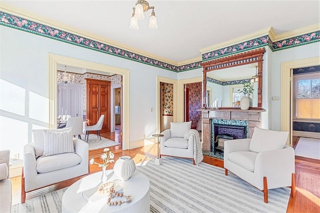 living room featuring a high end fireplace, ornamental molding, and hardwood / wood-style flooring