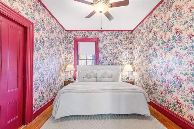 bedroom with ceiling fan, hardwood / wood-style floors, and ornamental molding