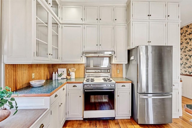 kitchen with white cabinets, stainless steel fridge, light hardwood / wood-style floors, and white range with gas cooktop