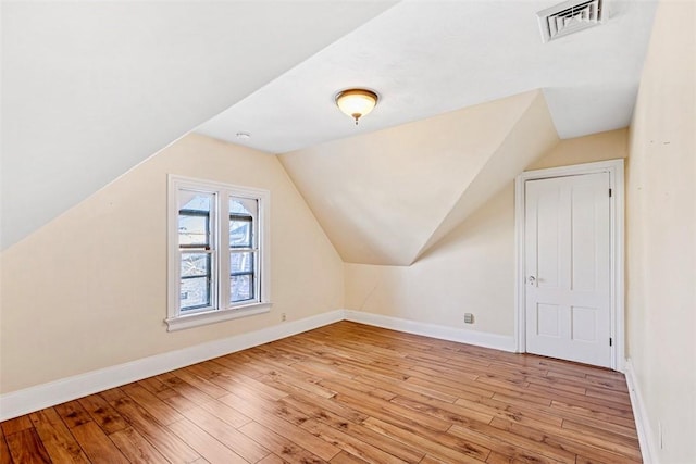 additional living space with lofted ceiling and light wood-type flooring