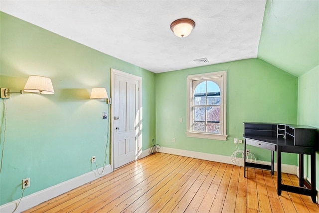 misc room featuring light hardwood / wood-style floors and vaulted ceiling