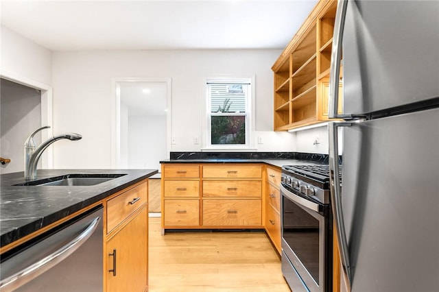 kitchen with sink, stainless steel appliances, and light wood-type flooring