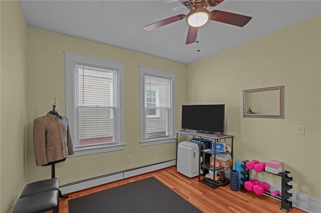 interior space featuring ceiling fan, baseboard heating, and hardwood / wood-style flooring