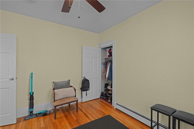 sitting room featuring ceiling fan, a baseboard radiator, and light hardwood / wood-style floors