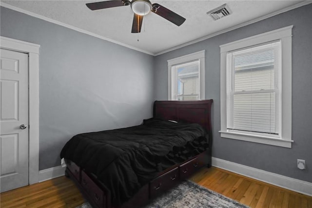 bedroom with ceiling fan, crown molding, dark hardwood / wood-style floors, and a textured ceiling