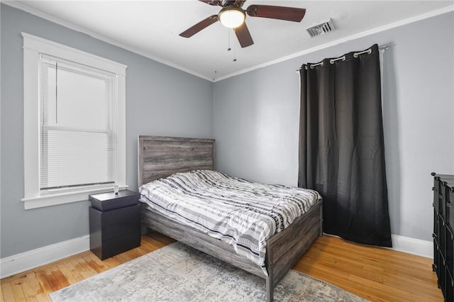 bedroom featuring ornamental molding, light wood-type flooring, and ceiling fan