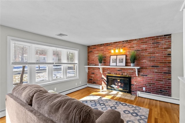 living room with a fireplace, wood-type flooring, and baseboard heating