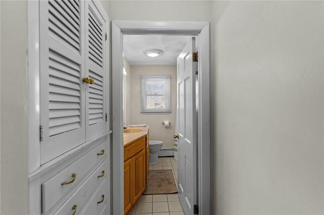 bathroom with tile patterned floors, toilet, vanity, and a baseboard heating unit