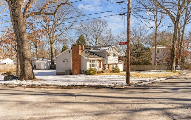 view of front of home featuring central AC and a storage shed