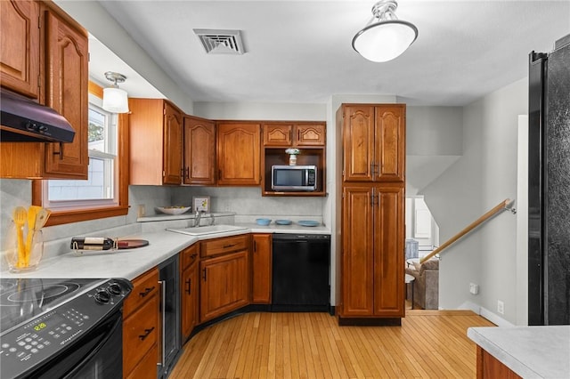 kitchen with sink, wine cooler, backsplash, black appliances, and light hardwood / wood-style flooring