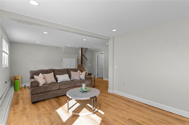 living room featuring light wood-type flooring and a baseboard heating unit